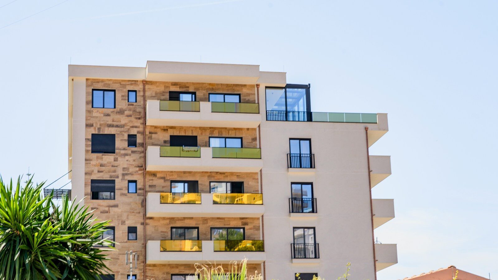 a tall building with lots of windows next to trees
